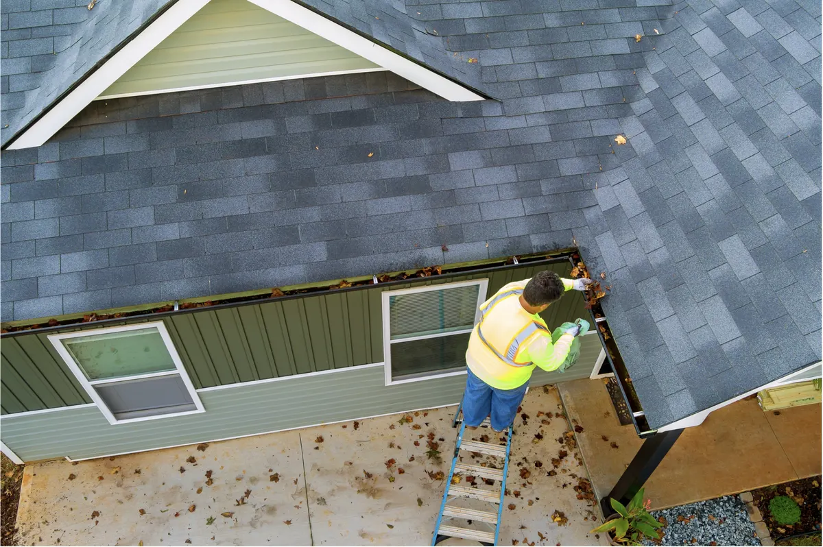 Gutter cleaning on a Pacific Northwest home under fall leaves